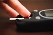 © nagaets - close up of male finger with blood drop and test stripe to checking blood sugar level by Glucose meter