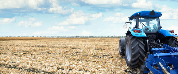 Fototapete - Modern tractor is working in the field