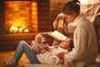 © JenkoAtaman - family mother and child reading book on winter evening by fireplace.