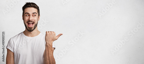 Fotografía Horizontal shot of handsome bearded young brunet male model has appealing appear
