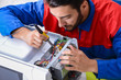 © Elnur - Young repairman fixing and repairing microwave oven
