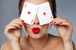 Woman with red lips is holding two aces in her hands