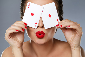 Wall Mural - Woman with red lips is holding two aces in her hands