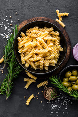 Poster - Pasta and ingredients for cooking on black background, top view. Italian food