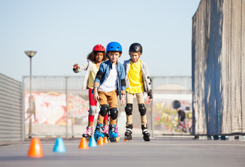 Wall Mural - Young inline skaters exercising on slalom course