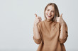 canvas print picture - Portrait of fair-haired beautiful female student or customer with broad smile, looking at the camera with happy expression, showing thumbs-up with both hands, achieving study goals. Body language
