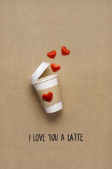 Wall Mural - Hot drink / Creative concept photo of take away coffee cup with hearts on brown background.