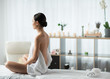 Peace and luxury. Profile of calm young woman sitting on massage table at spa and meditating. Copy space