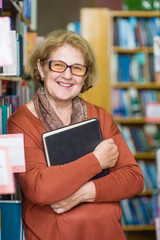 Wall Mural - Happy senior woman in the library