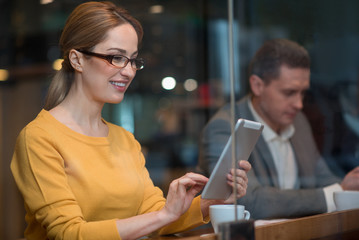 Poster - Portrait of outgoing lady typing in electronic tablet while situating in cafe. Rest concept