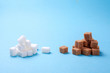 © adragan - White and brown sugar cane sugar cubes on a blue background. Copy space for text