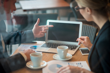 Aufkleber - Close up man hand pointing at screen of laptop. Woman looking at it. Work concept