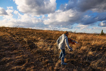 Boy Walking Through A Field On A Windy Day