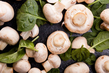 Top Close Up View On Raw Fresh Mushrooms And Spinach Leaves