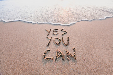 yes you can, motivational inspirational message concept written on the sand of beach