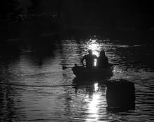Silhouettes Of  Man And Woman In Boat At Daumesnil Lake (Paris, France). Sunset. Light And Shadow. Romance Background. Harmony With Nature Idea. Black And White Photo.