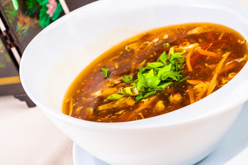 Chinese spicy and sour soup with chicken in white plate