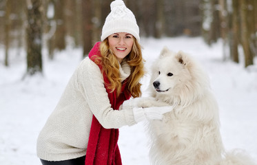 Pretty Young Woman in Snowy Winter Forest Park Walking with her Dog White Samoyed Seasonal 