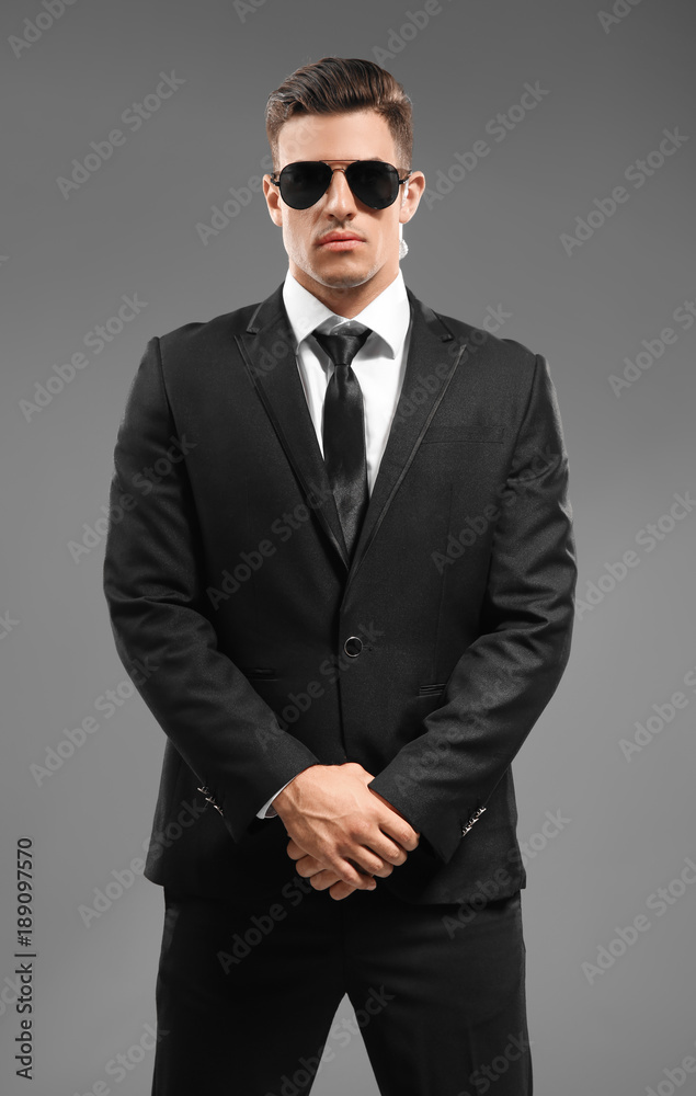 Handsome security guard on grey background