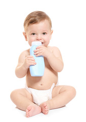 Wall Mural - Cute baby with bottle of body cream on white background