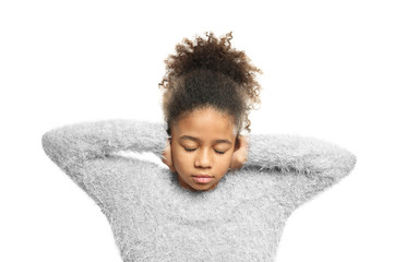 Little African-American girl covering her ears on white background. Hearing problem