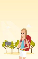 Poster - Young caucasian white traveler woman holding a selfie-stick and making selfie. Smiling traveler woman with a backpack taking photo with a mobile phone. Vector cartoon illustration. Vertical layout.