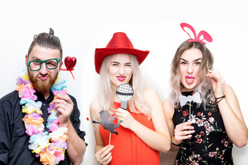 three people girls man posing party props photo booth white plain background studio hat