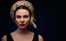 Close Up Portrait Of Woman With Snake Around Her Head On Dark Background