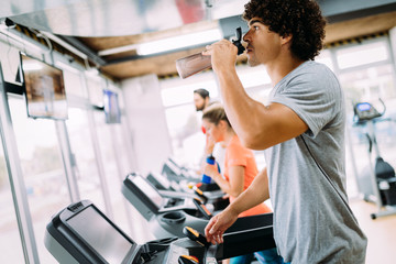 Young handsome man doing cardio training in gym