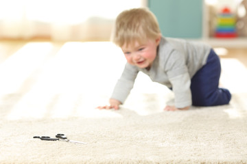 Wall Mural - Baby in danger crawling towards a scissors