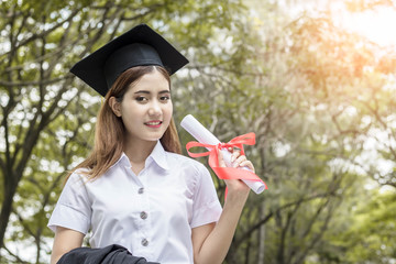 happy graduate showing certificated in hand with sky background