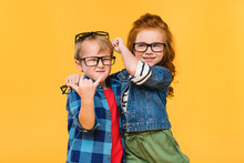 Portrait Of Smiling Kids In Eyeglasses Isolated On Yellow