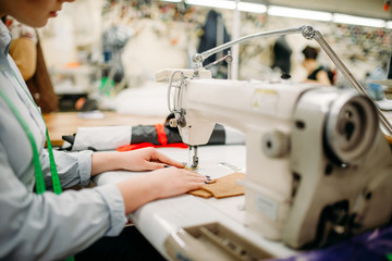 Tailor hands sews fabrics on a sewing machine