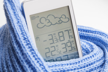 Wall Mural - Weather station device in the light blue knitted scarf on a light background. Closeup, selective focus