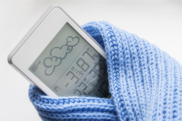 Wall Mural - Weather station device in the light blue knitted scarf on a light background. Closeup, selective focus