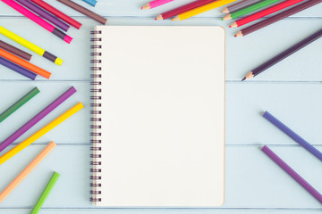 Wall Mural - blank notebook with colorful pencil on blue wooden table,top view