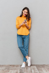 Wall Mural - Full length image of Happy brunette woman in sweater