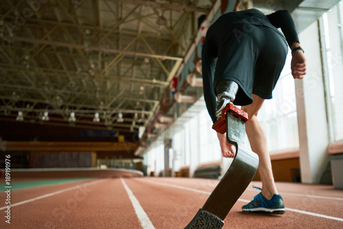 Fotografía Motivational image of young amputee athlete on start position on running track i