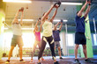 © Syda Productions - group of people with kettlebells exercising in gym
