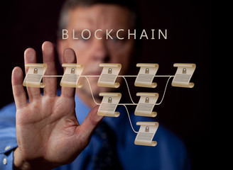 Senior technologist holding hand up to blockchain illustration