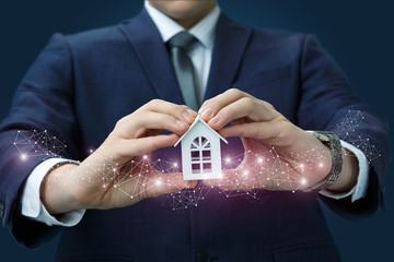 Wall Mural - Businessman in the hands shows the model of the house.