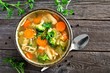 © Jenifoto - Homemade chicken vegetable soup, top view on an aged rustic wood background