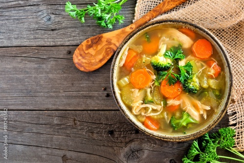 Fotografía Homemade chicken vegetable soup, above view with copy space on a rustic wooden b
