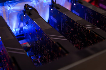 Fototapete - Close-up equipment for mining crypto-bitcoin, ether. Video cards, motherboards, blue lights