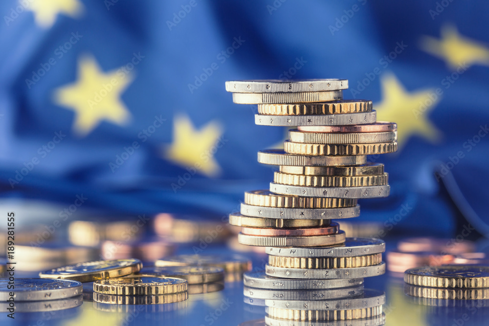 Euro money.Euro Flag.Euro currency.Coins stacked on each other in different positions. European union flag - obrazy, fototapety, plakaty 