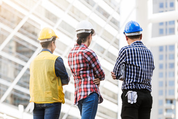 Wall Mural - Engineers man and woman back view of workers building construction in city