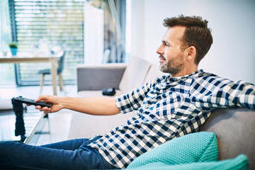 Relaxed man on sofa watching tv