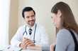 © Jestercine - Attractive Doctor working at hospital. Doctor try to treat woman for any problem. He holding her hand.