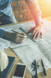 Concept architects,engineer holding pen pointing equipment architects On the desk with a blueprint in the office, Vintage, Sunset ligth.Selective Focus