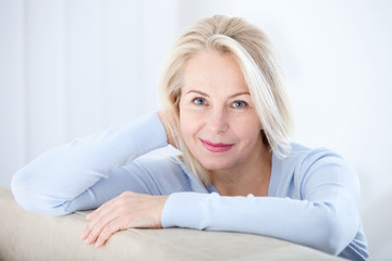 Wall Mural - active beautiful middle-aged woman smiling friendly and looking in camera. woman's face closeup. rea